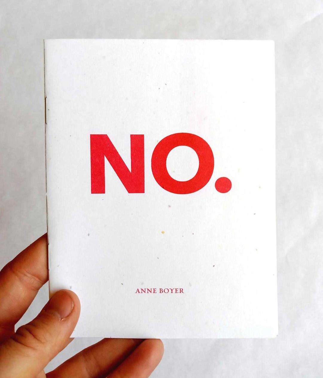 hand holding a small zine with the word NO printed in large, red, blocky letters on the cover. author is anne boyer.